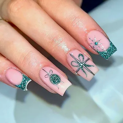 Square nails with emerald glitter tips, a hand-painted bow, a bauble and a snowflake